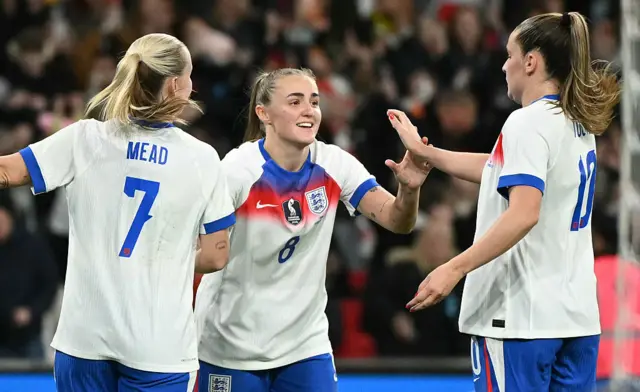 England's midfielder #08 Georgia Stanway (C) celebrates scoring the team's fifth goal from the penalty sopt, with England's striker #07 Beth Mead (L) and England's midfielder #10 Ella Toone during the women's International football friendly match between England and China at Wembley Stadium in London on November 29, 2025.
