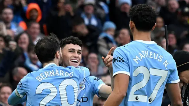 Phil Foden celebrates scoring with his teammates Bernardo Silva and Matheus Nunes
