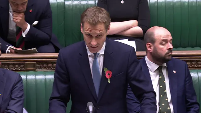 Shadow home secretary Chris Philp in the Commons wearing a blue suit and poppy.