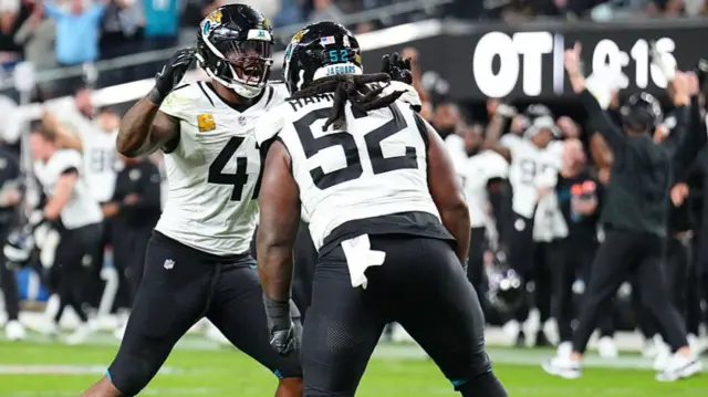 Josh Hines-Allen and DaVon Hamilton celebrate as the Jacksonville Jaguars seal victory at the Las Vegas Raiders