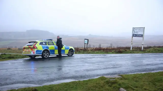 A police officer mans a road block near the site of the train derailment near Shap in Cumbria.