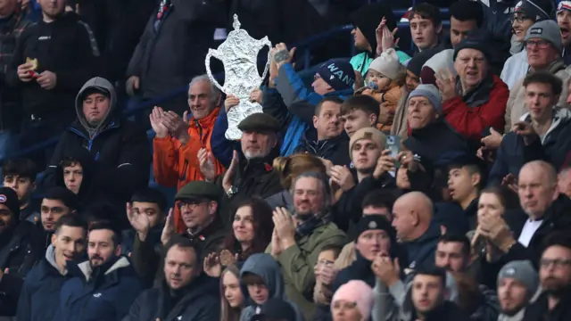A Bolton fans holds up a tinfoil FA Cup trophy