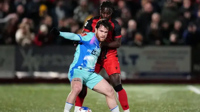 Leyton Orient's Aaron Connolly holds off the challenge of Tamworth's Kwaku Donkor