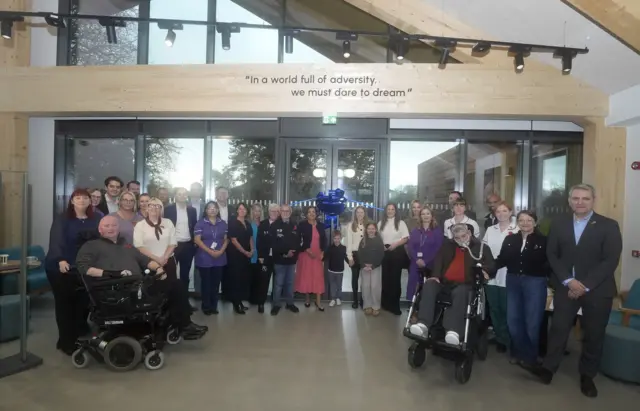 Patients, staff and Rob Burrow's friends and family gather in the main entrance of the Rob Burrow MND Centre in Leeds ahead of its opening