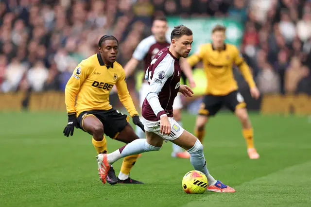 Matty Cash of Aston Villa holds off Jean-Ricner Bellegarde of Wolves