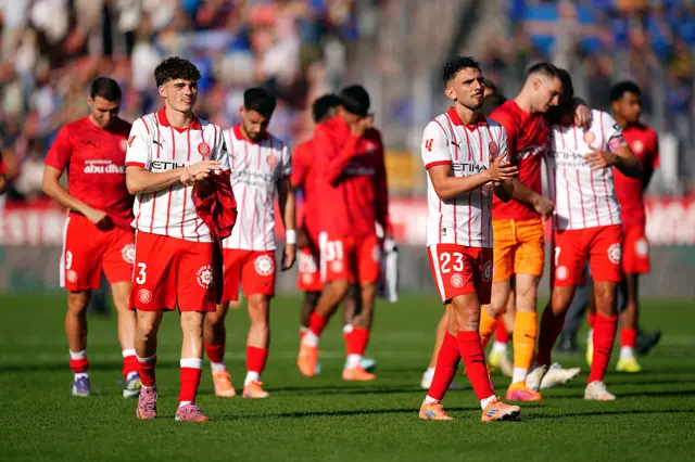 Girona players walking on a pitch