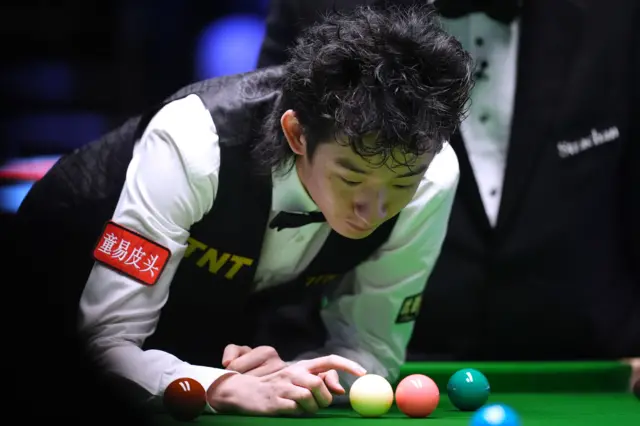 Wu Yize places the white ball during his match against Michael Holt
