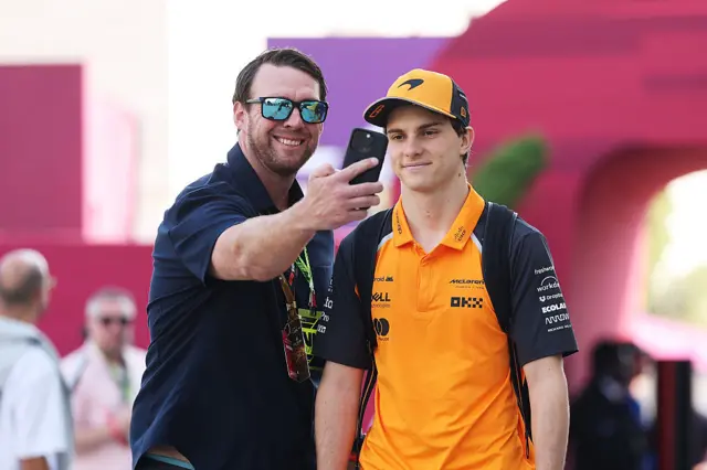 A fan takes a picture with Oscar Piastri in the Qatar paddock