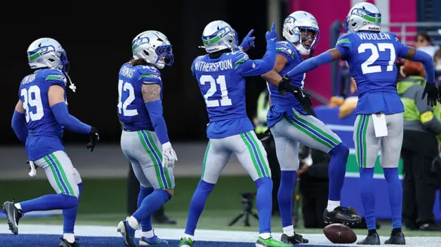 Seattle Seahawks defenders celebrate after intercepting Vikings quarterback Max Brosmer.