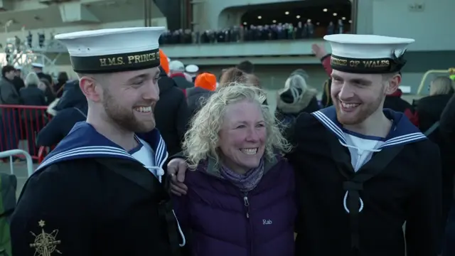 Vicky Mackinnon is in the middle of her two boys, wearing their Royal Navy uniform and they grinning widely