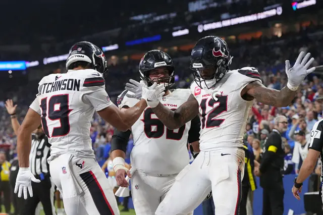 Nico Collins celebrates with teammates after scoring a fourth quarter touchdown for the Houston Texans
