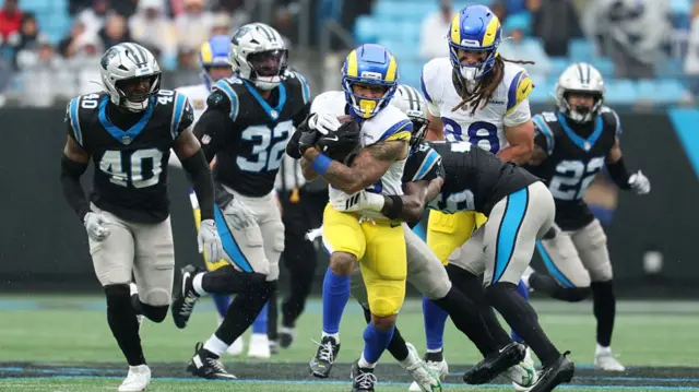 Kyren Williams runs through the centre of a number of Panthers defenders.