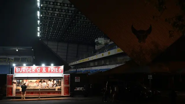 A burger van is illuminated outside Oxford's Kassam Stadium