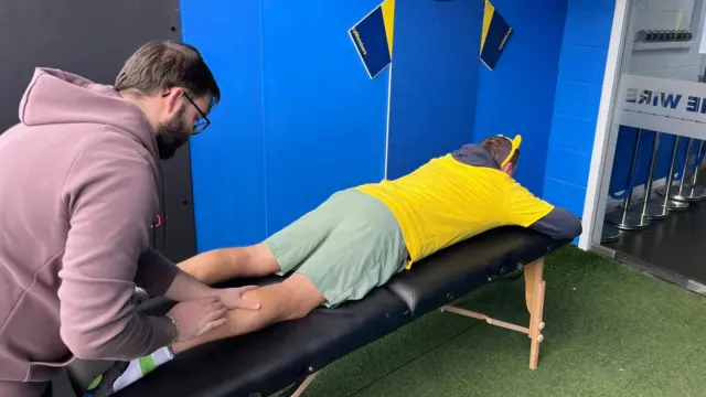 Phil lies down and gets a calf massage.