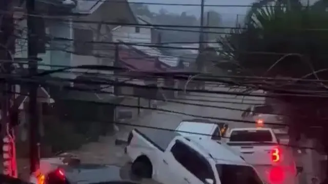 A frame from the verified video shows homes under water and submerged cars in the street of Cebu City