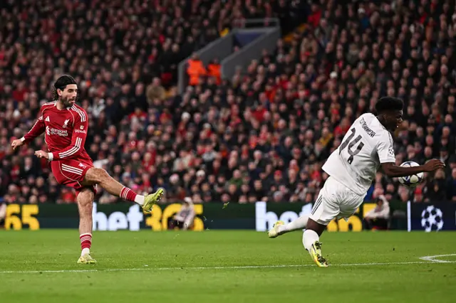 Dominik Szoboszlai slams the ball at Aurelien Tchouameni just outside the box.
