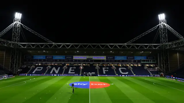 A photograph of Deepdale stadium under floodlights
