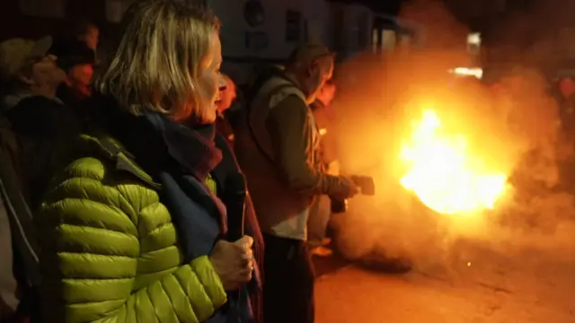 Victoria Graham stood next a flaming barrel.