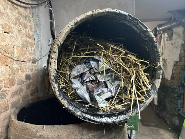Inside a tar barrel which is lined with tar and has straw and paper inside of it.