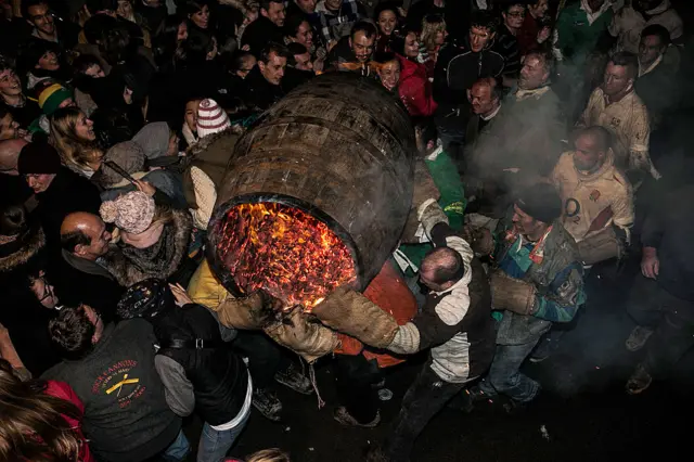 A burning barrel soaked in tar is carried at the annual Ottery St Mary Tar Barrel festival on November 5 2013 in Ottery St Mary, Devon, England.