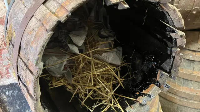 Inside a wooden barrel which is lined with tar, straw and paper."