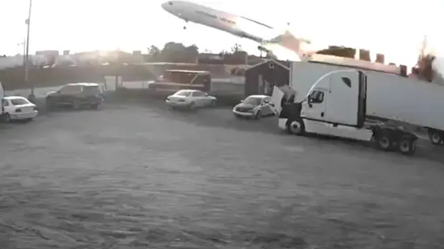 A plan beginning to tilt to one side as a fireball emerges in a screengrab of CCTV footage from a car park