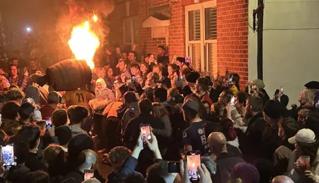 A man with a tar barrel on his back.