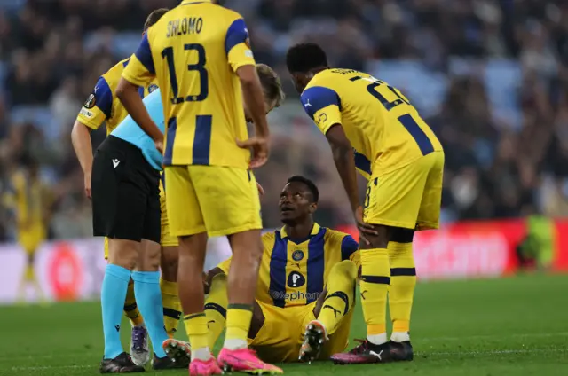 Mohamed Ali Camara of Maccabi sits on the ground after sustaining an injury