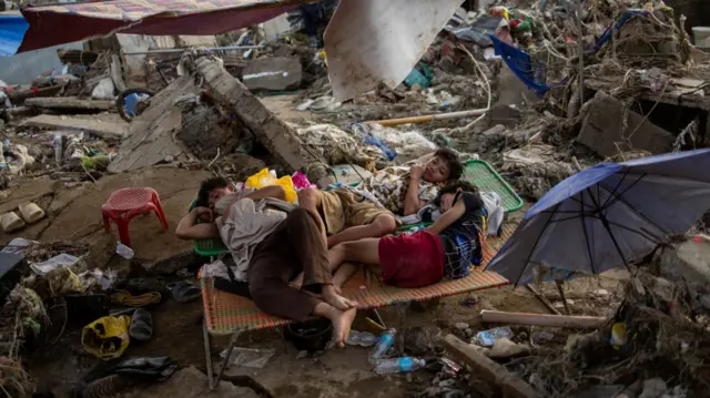 Children lie on makeshift beds amid piles of debris in Cebu, Philippines