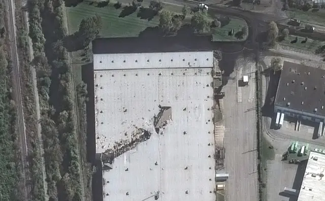A satellite image showing a large gash on the roof of a building