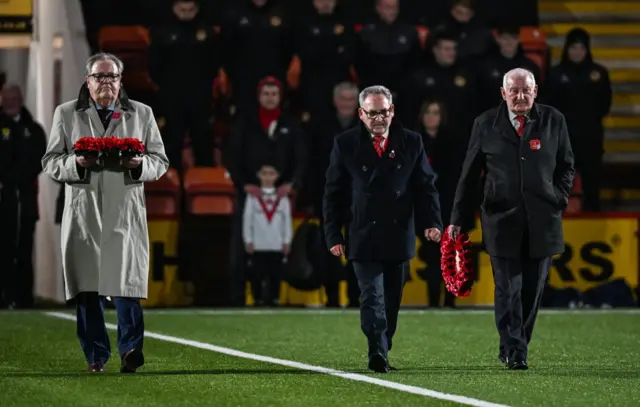 Poppy wreath is brought onto the pitch