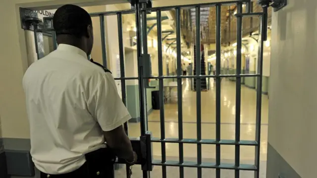 A prison officer locks a gate at HMP Wormwood Scrubs, west London