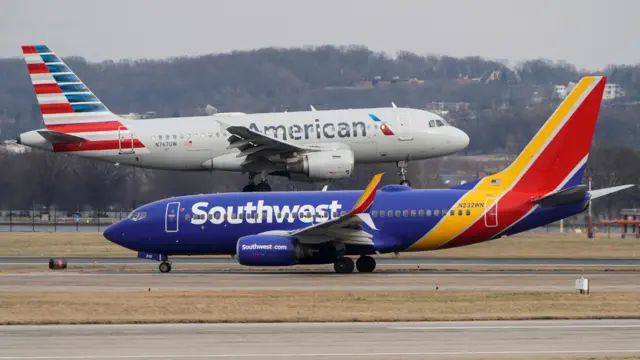A Southwest Airlines aircraft taxis as an American Airlines aircraft lands at Reagan National Airport in Arlington, Virginia, US