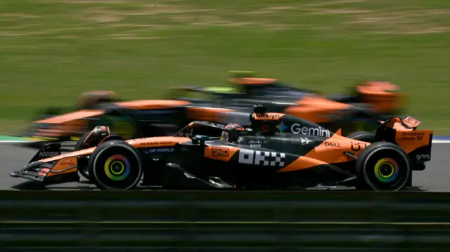A blurred image of the McLarens of Oscar Piastri and Lando Norris alongside each other during Sao Paulo Grand Prix practice