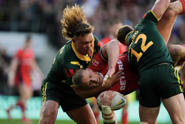 England's Mikolaj Oledzki is tackled by Australia's Reuben Cotter and Hudson Young