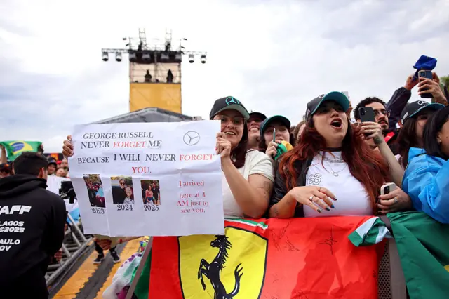 Fans hold up sings in the fan zone in Sao Paulo