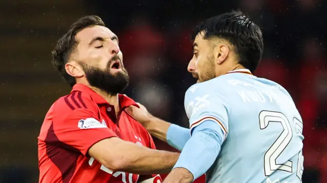 Graeme Shinnie and Johnny Koutroumbis clash