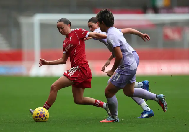 Mia Enderby of Liverpool runs with the ball whilst under pressure from Kiko Seike of Brighton & Hove Albion