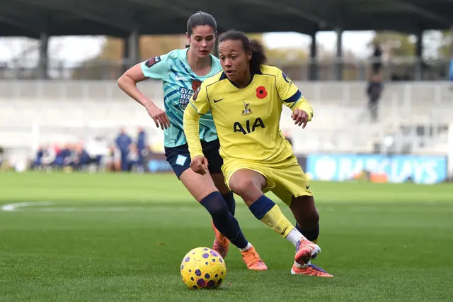 Drew Spence of Tottenham Hotspur runs with the ball whilst under pressure from Freya Godfrey