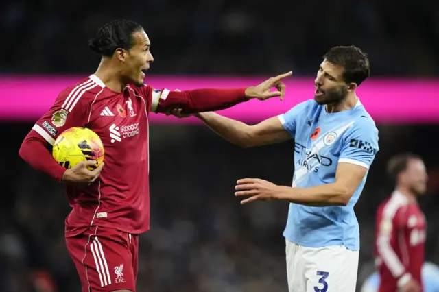 Liverpool's Virgil van Dijk (left) attempts to keep the ball from Manchester City's Ruben Dias during the Premier League match at Etihad Stadium, Manchester.