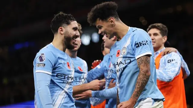 Nico O'Reilly of Manchester City celebrates scoring his team's third goal with teammate Rayan Cherki