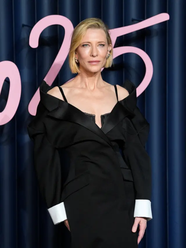 Cate Blanchett wears an off-the-shoulder black gown that has the likeness of a tuxedo jacket