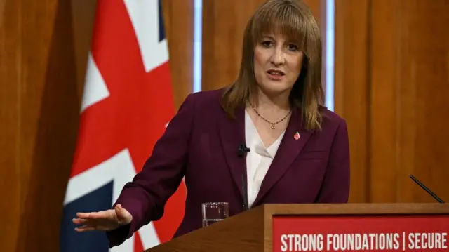 Chancellor Rachel Reeves at the Downing Street news conference room on 4 November - she is wearing a burgundy suit jacket, white blouse and a small poppy