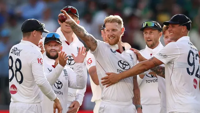 Ben Stokes (centre, surrounded by his team-mates) holds the ball up in celebration