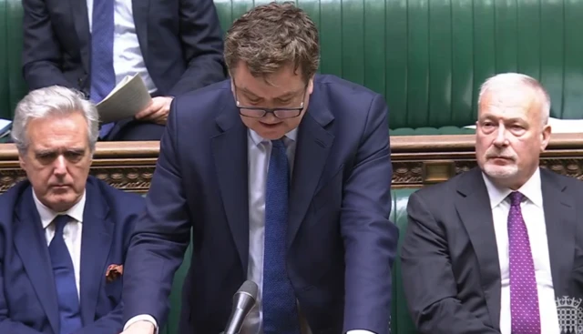 Shadow chancellor Mel Stride is wearing a navy suit and blue tie, as he questions James Murray
