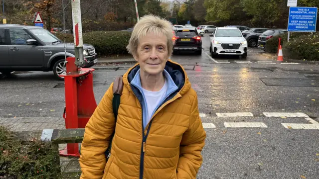 Older woman wearing coat on roadside