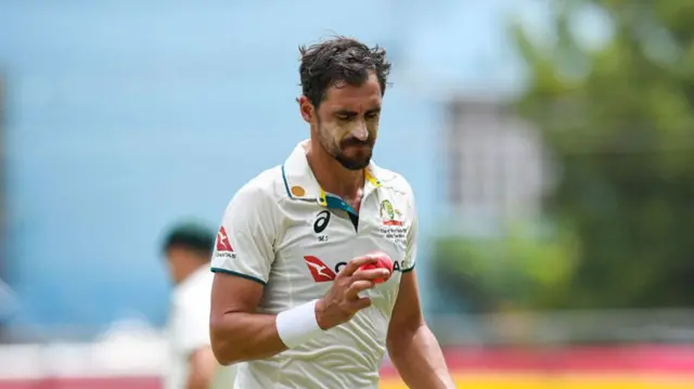 Mitchell Starc looks at the pink ball