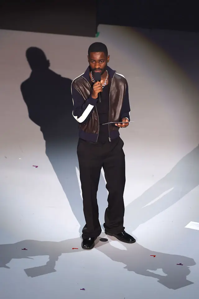 Dave accepts the British Menswear Designer of the Year award on behalf of the winner, Grace Wales Bonner