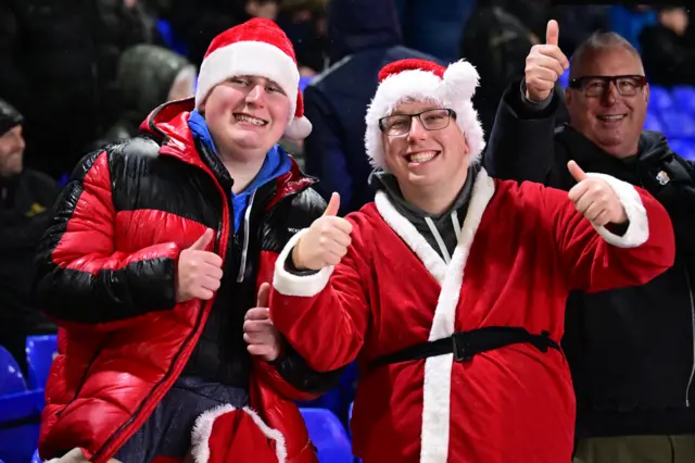 Two fans dressed as Santa Claus