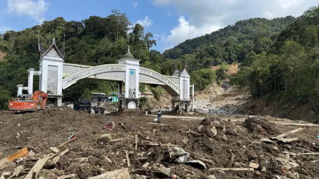 Soil and debris piled up near a road, with the round arch marking the Twin Bridges